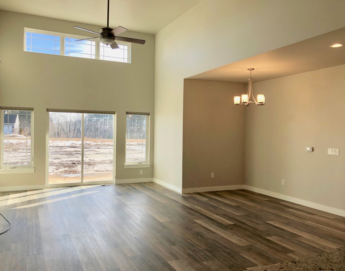 Spacious living and dining area with hardwood floors and large windows.