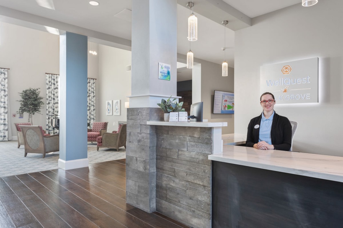 A modern office lobby with a receptionist at the desk.