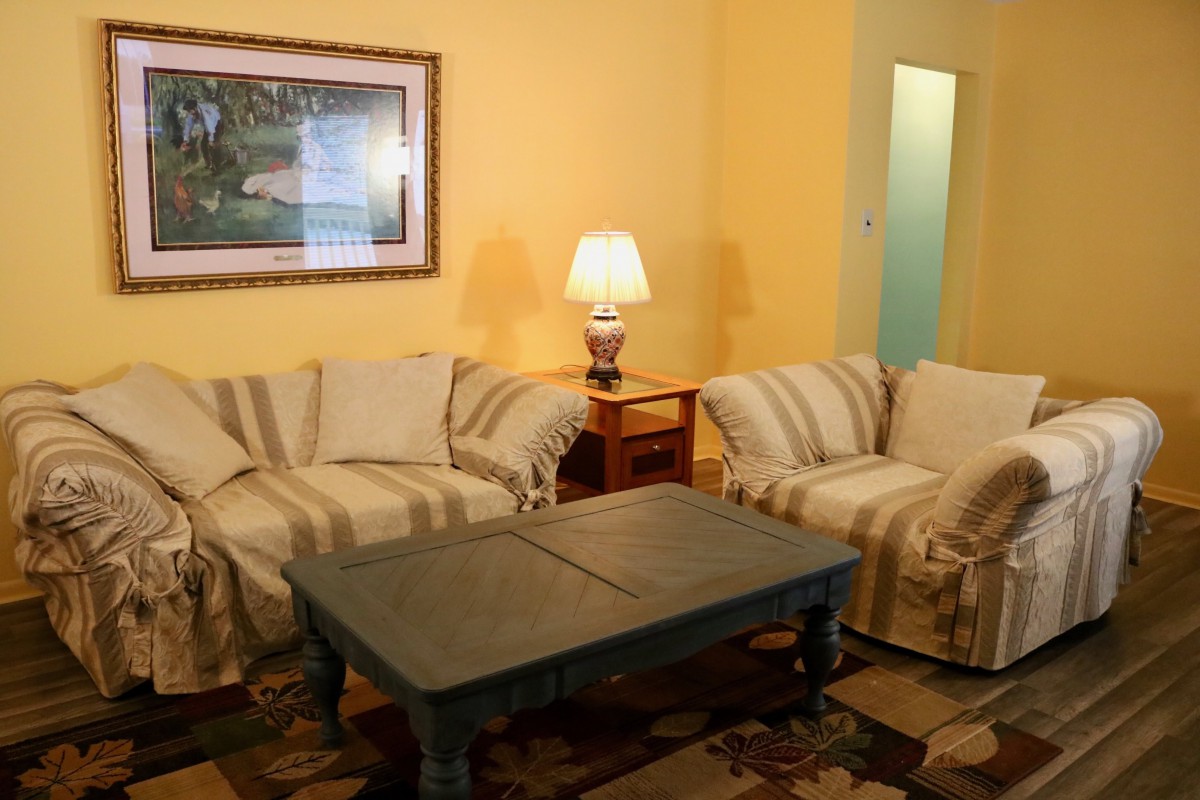 A cozy living room with sofas, a coffee table, and ambient lighting.