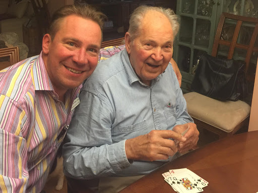 A joyful moment shared between two men while playing cards.