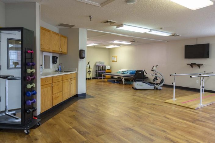A spacious rehabilitation room equipped with physical therapy and exercise equipment.