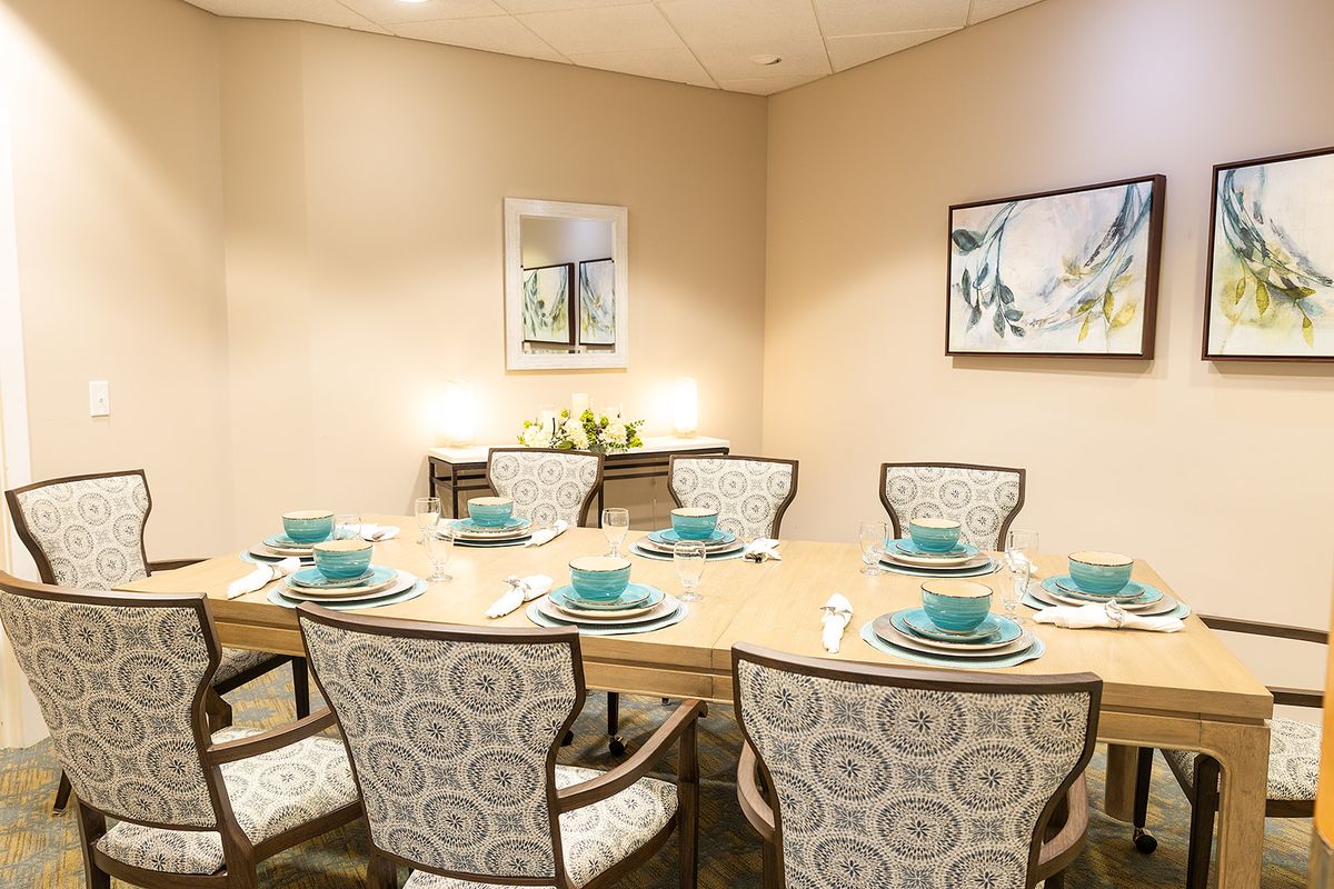 A well-decorated dining room with a neatly set table and elegant chairs.