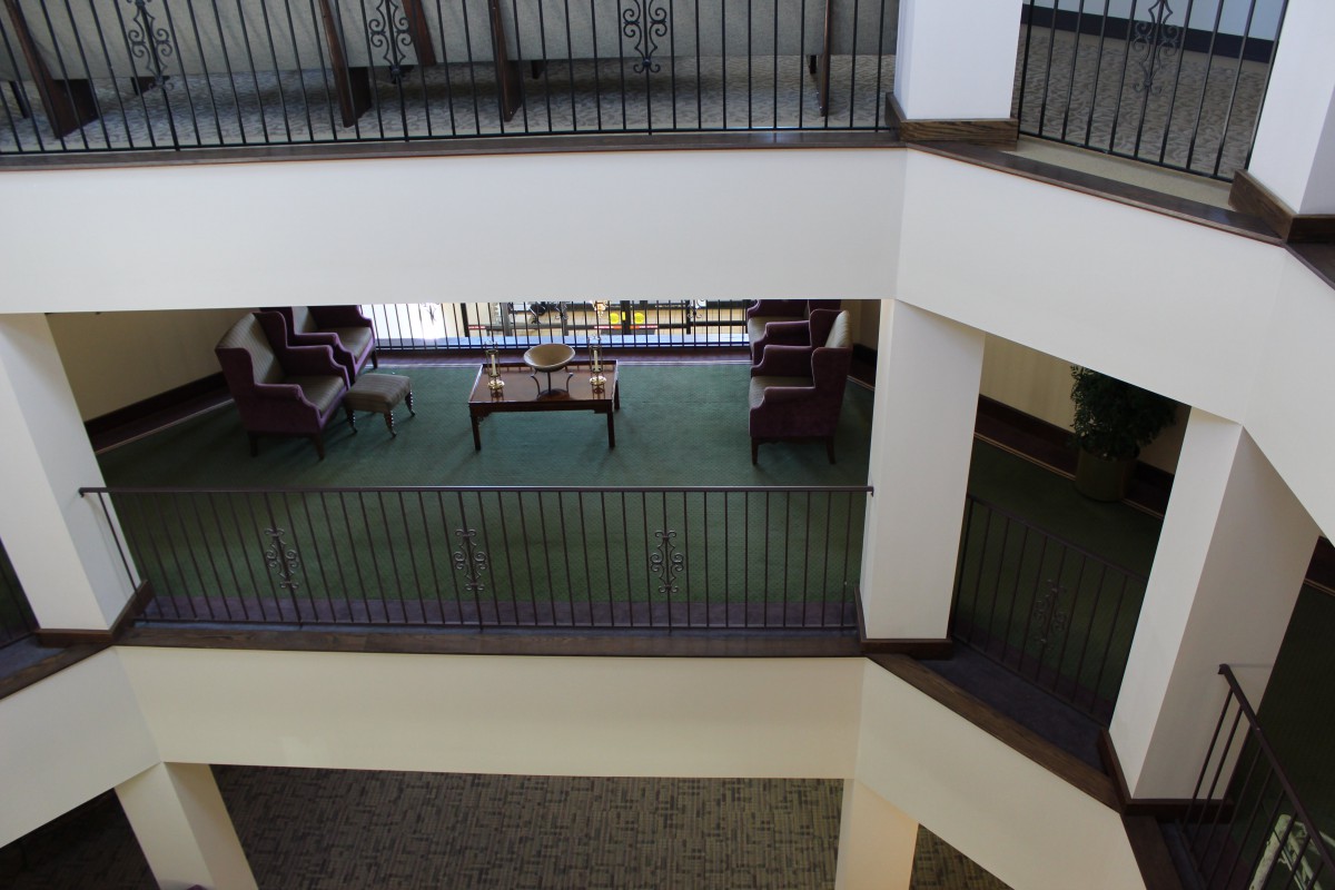 An interior view of a multi-story lobby with a seating area and balconies overlooking the atrium.