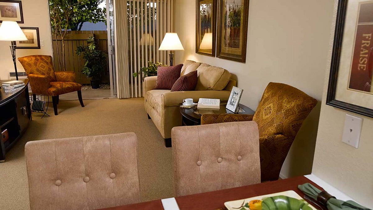 A cozy living room with a sofa, dining table, and warm lighting.