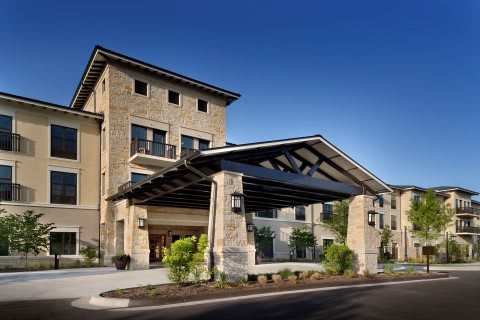 A modern hotel building with a stone facade and main entrance.