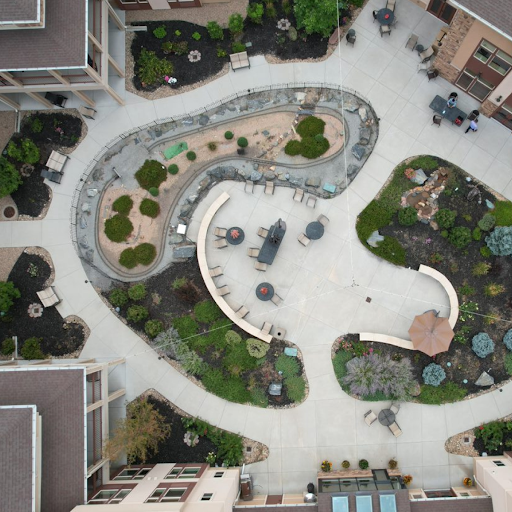 An aerial view of a beautifully designed park featuring winding pathways, gardens, and recreational spaces.