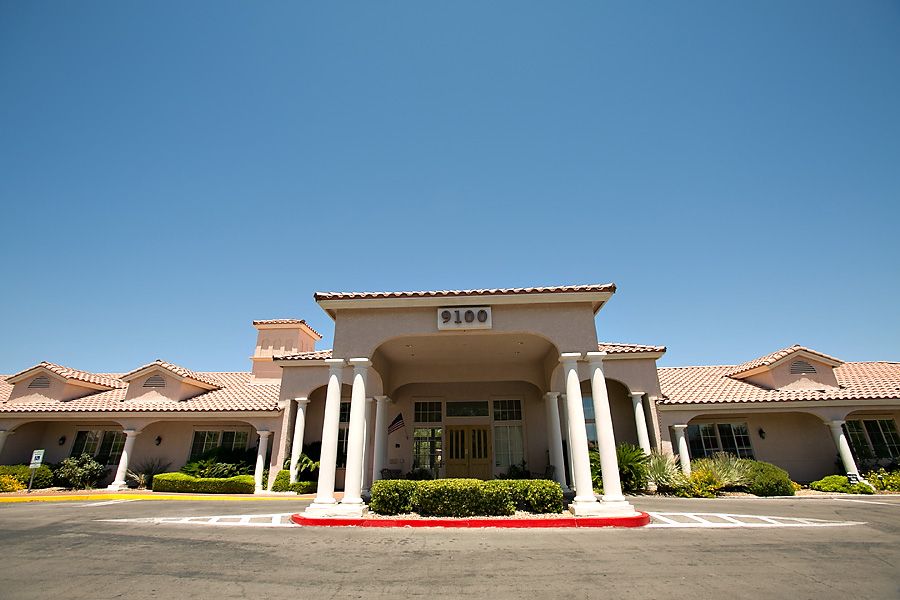 The front entrance of a building featuring pillars and a clear blue sky.