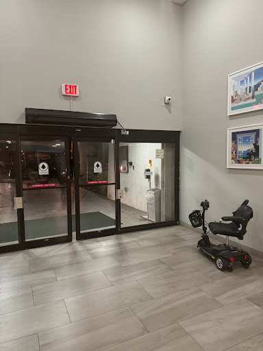 A view of the entrance featuring automatic doors and a mobility scooter parked nearby.