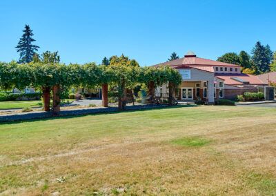 A picturesque house surrounded by a lush garden under a clear blue sky.