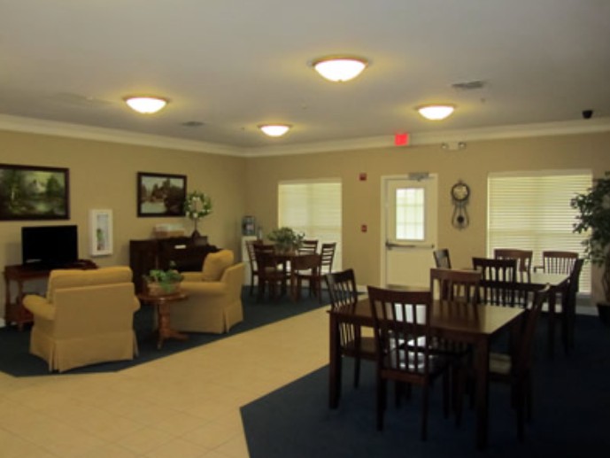 A cozy living room area with tables, chairs, and sofas arranged for relaxation.