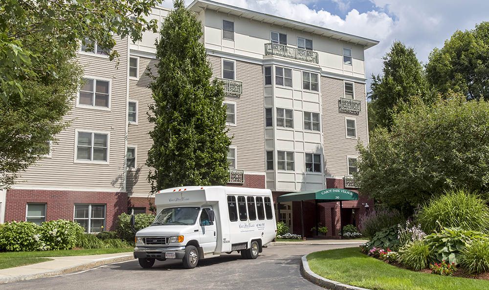 A shuttle bus parked in front of a hotel building.