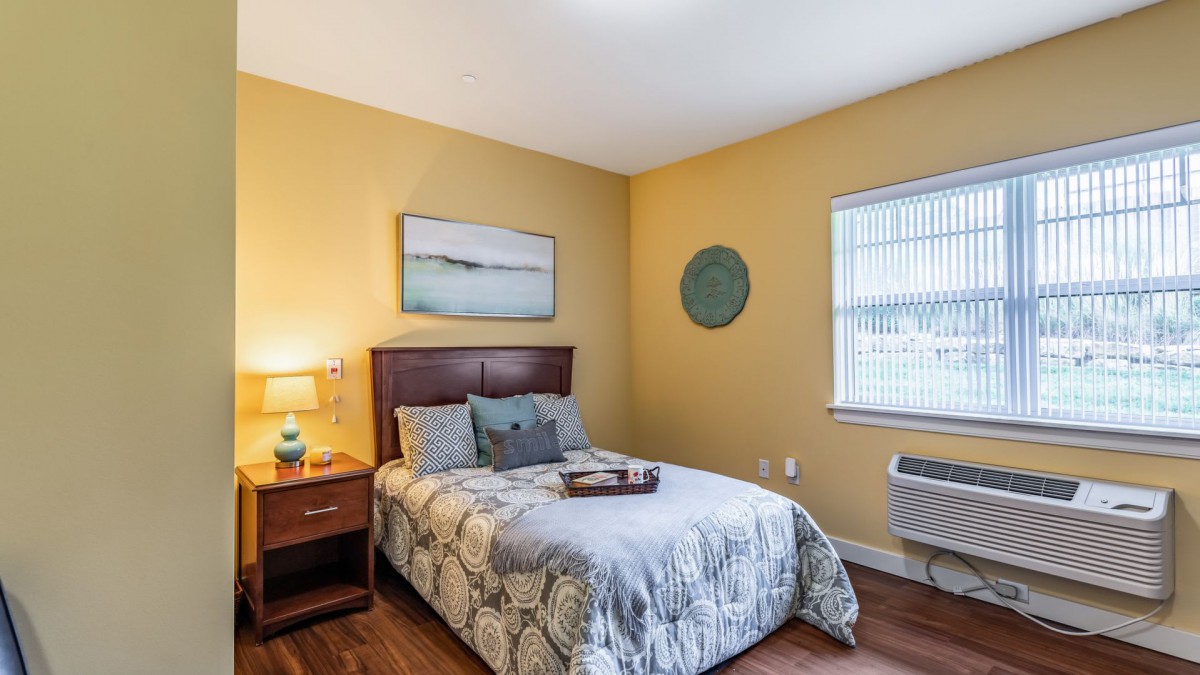 A cozy bedroom with a double bed, nightstand, and wall art.