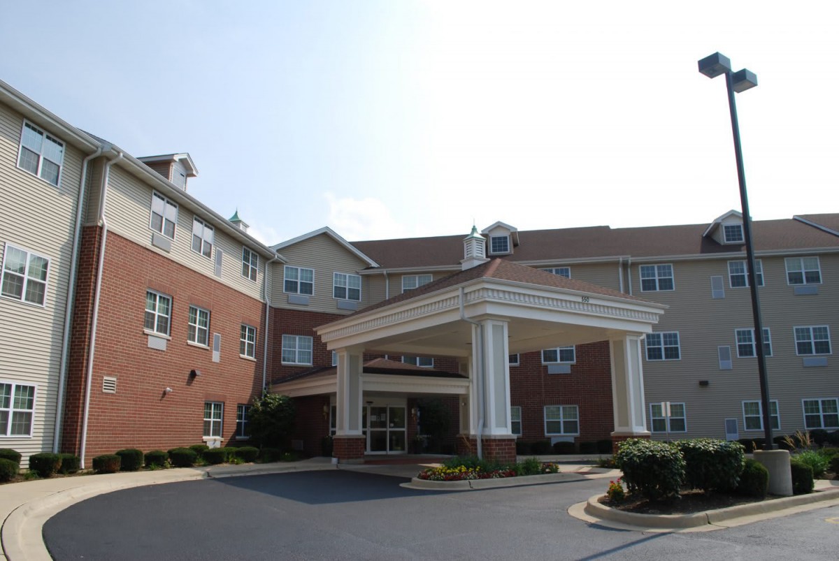 The image shows the front entrance of a multi-story building with a porte-cochre.
