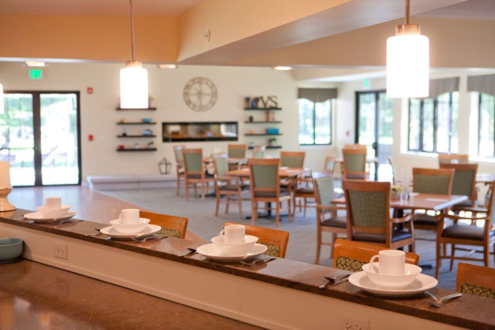 A modern and bright dining room with neatly arranged tables and chairs, featuring contemporary decor.