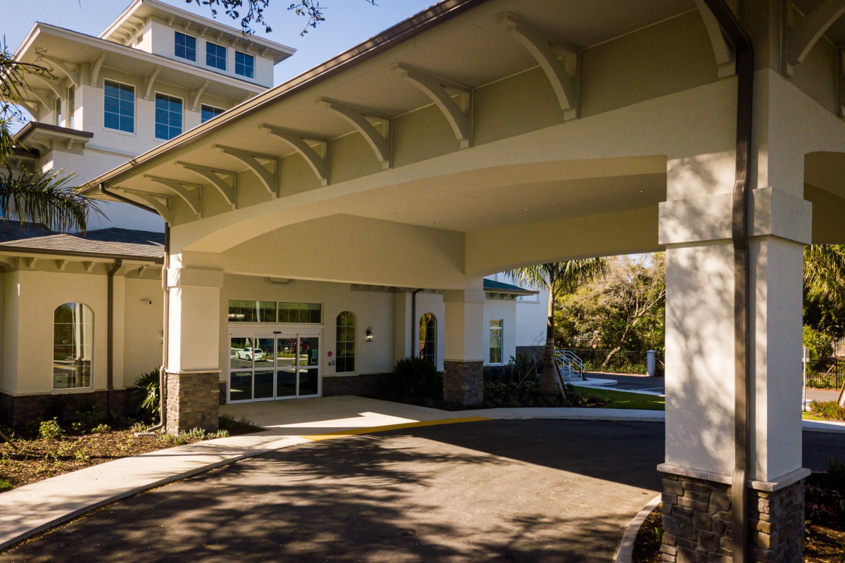 A view of a building entrance featuring a large canopy and modern architectural design.