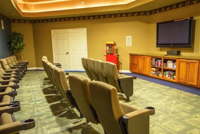 A cozy home theater room featuring comfortable seating, a large television, and a popcorn machine.