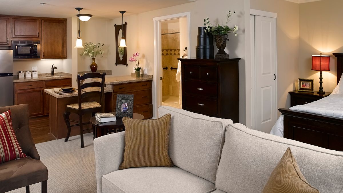 A cozy living room with a beige couch, adjacent dining area, and elegant decor.