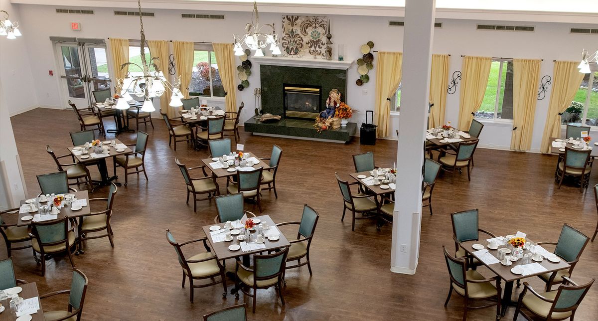 A spacious dining room with set tables and chairs, decorated with elegant furnishings.