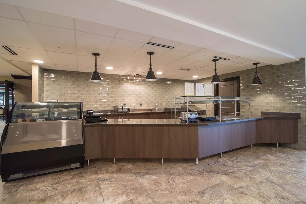 Modern cafe interior with a serving counter and overhead lighting.