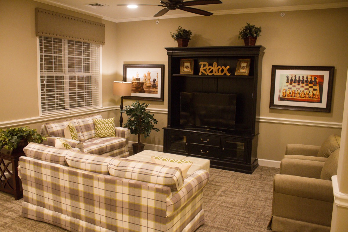 A cozy living room with plaid sofas and a large entertainment center.