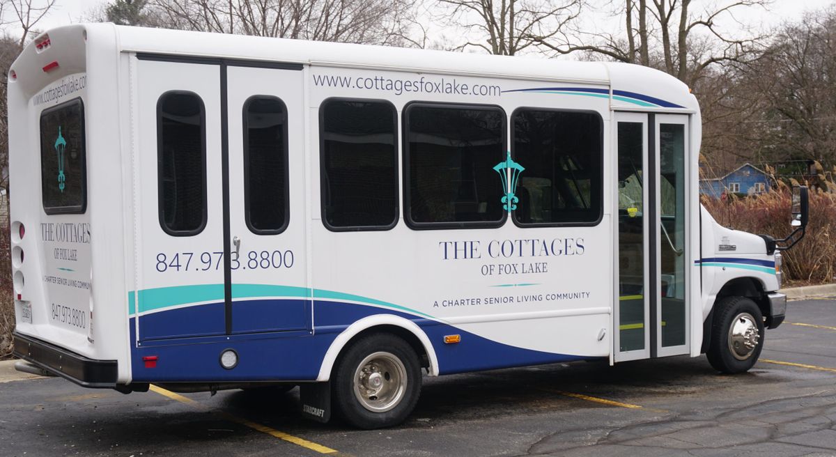 A shuttle bus labeled 'The Cottages' parked in a lot.