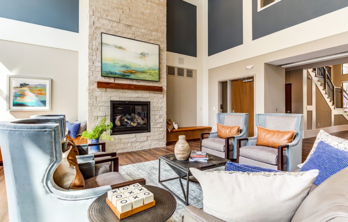 A modern living room with stylish decor, featuring a fireplace and comfortable seating.