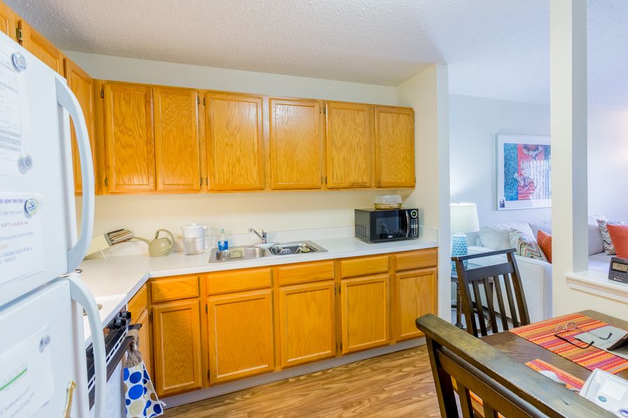 A cozy kitchen with wooden cabinets and a dining area.