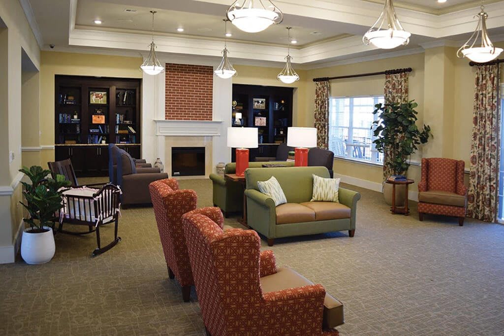 A cozy living room with comfortable seating, a fireplace, and elegant lighting.