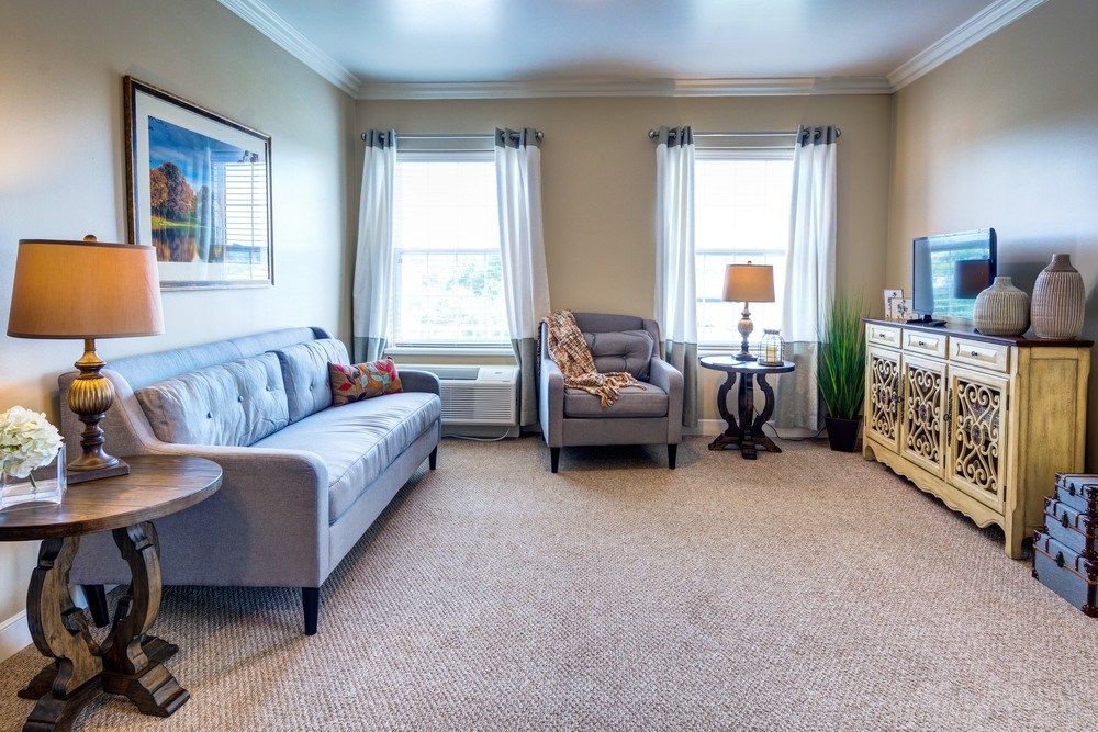 A cozy living room with modern furniture and large windows.