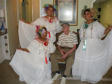 A group of people dressed in traditional cultural attire posing indoors.