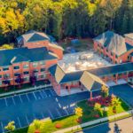 Aerial view of a hotel resort surrounded by lush greenery and trees.