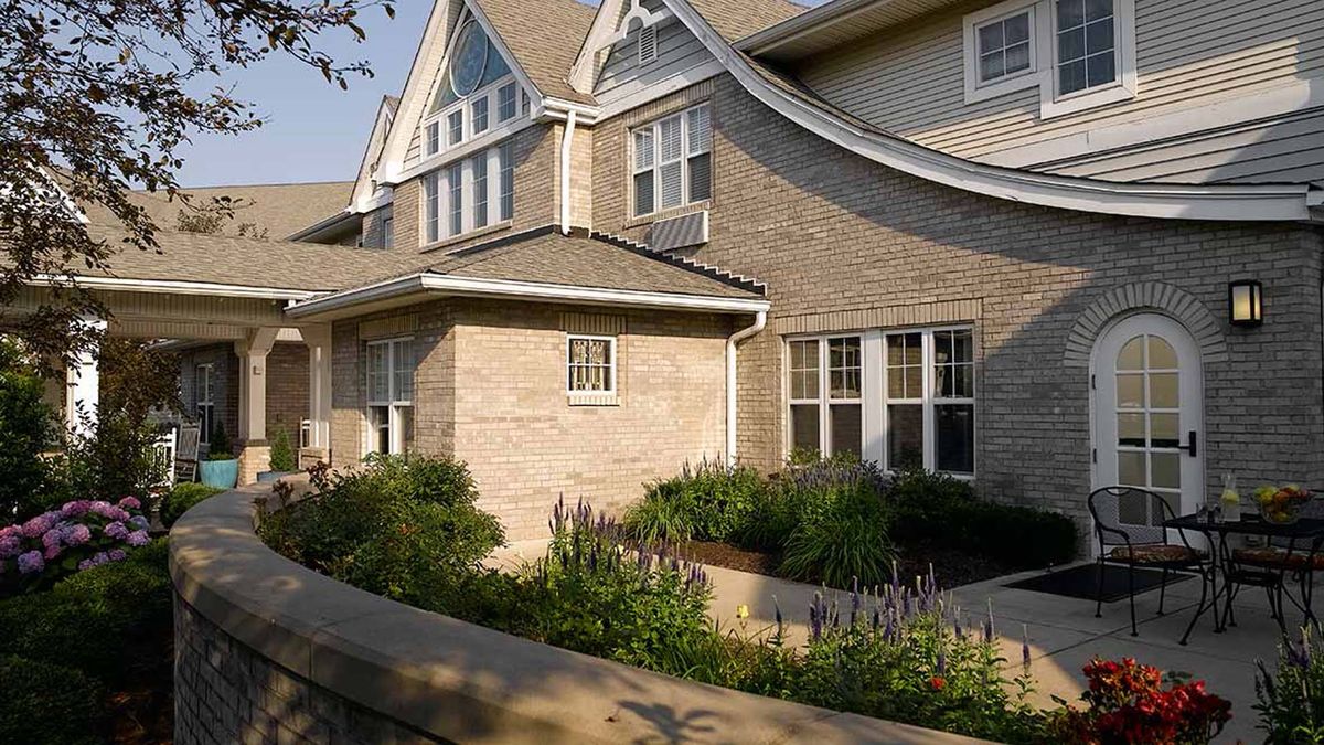 A beautiful residential house with brick exterior and lush garden landscaping.