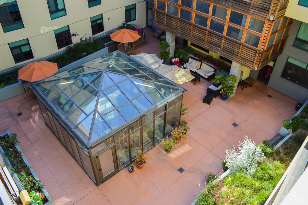 Aerial view of a courtyard featuring a glass-enclosed structure with surrounding seating areas.