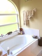 A cozy bathroom with a bathtub and neatly arranged towels hanging from the wall.
