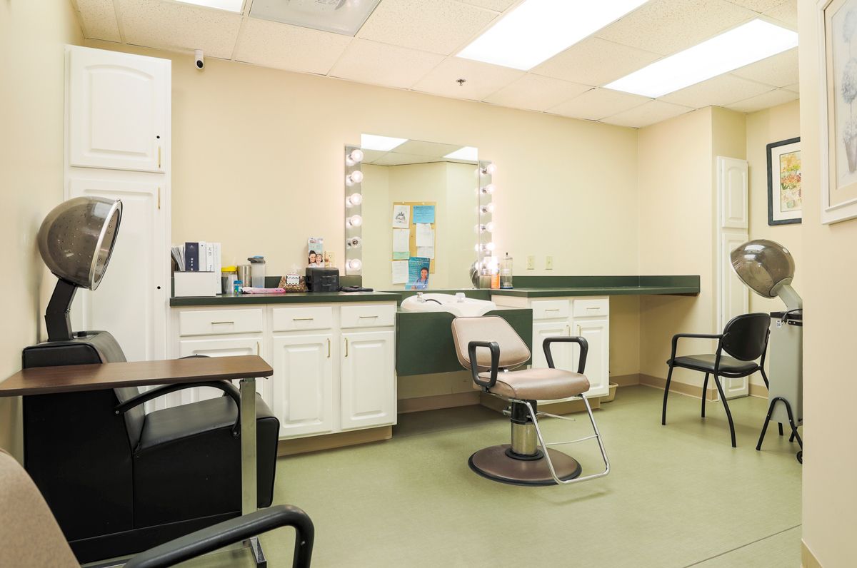 A modern hair salon with a styling chair and vanity mirror, featuring a clean and bright interior.