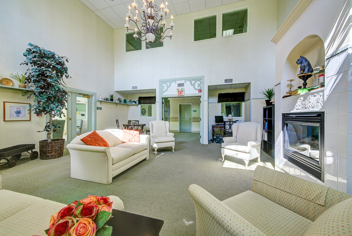 A spacious and well-lit living room with modern furniture and a chandelier.