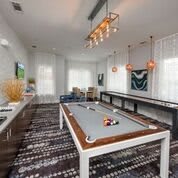 A modern billiard room with a stylish pool table and contemporary lighting.