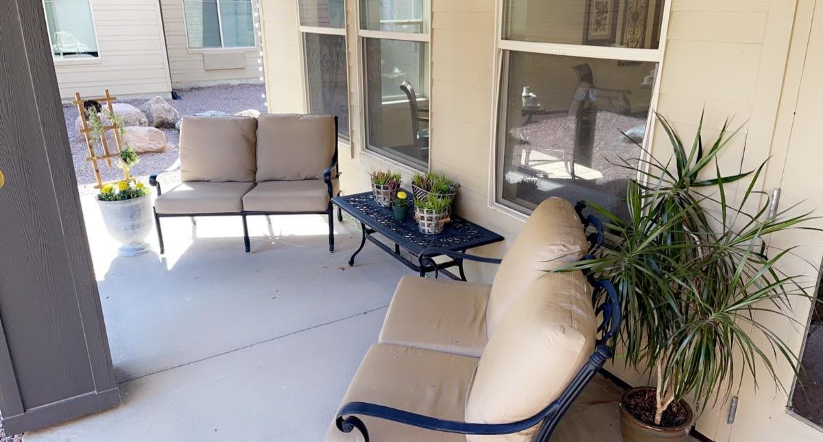 Cozy patio setup with cushioned seating and plants.