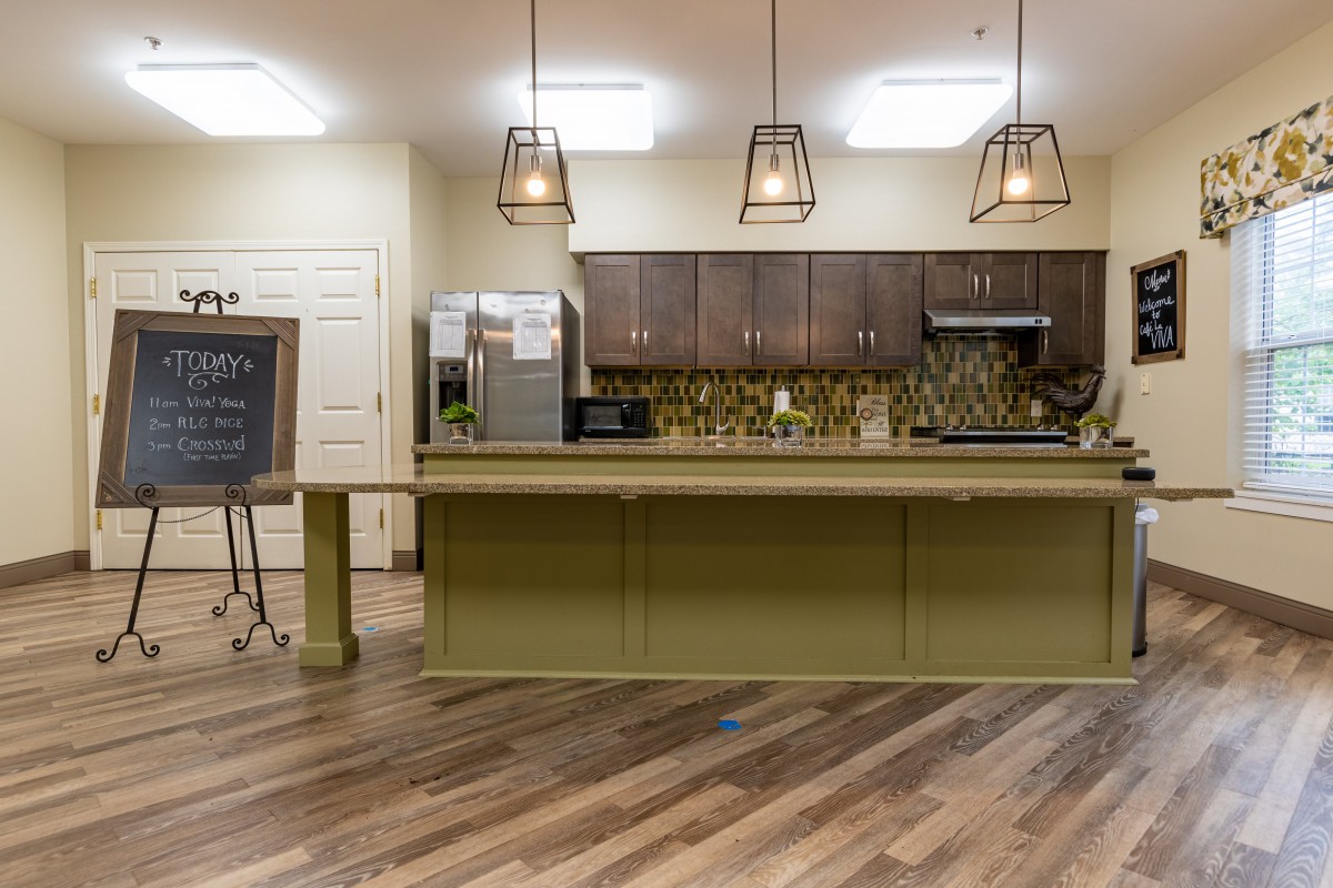 A modern kitchen with an island and stylish pendant lights.
