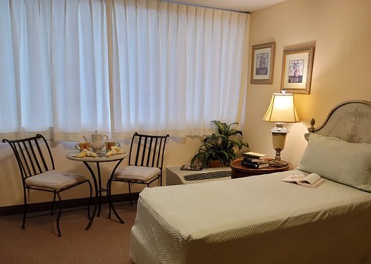 A cozy treatment room featuring a massage table, seating area, and warm decor.