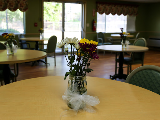 A lovely arrangement of flowers in a vase placed on a table in a bright indoor dining area.