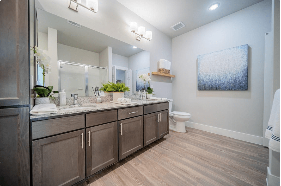 A modern bathroom featuring a double vanity, large mirror, and minimalistic decor.