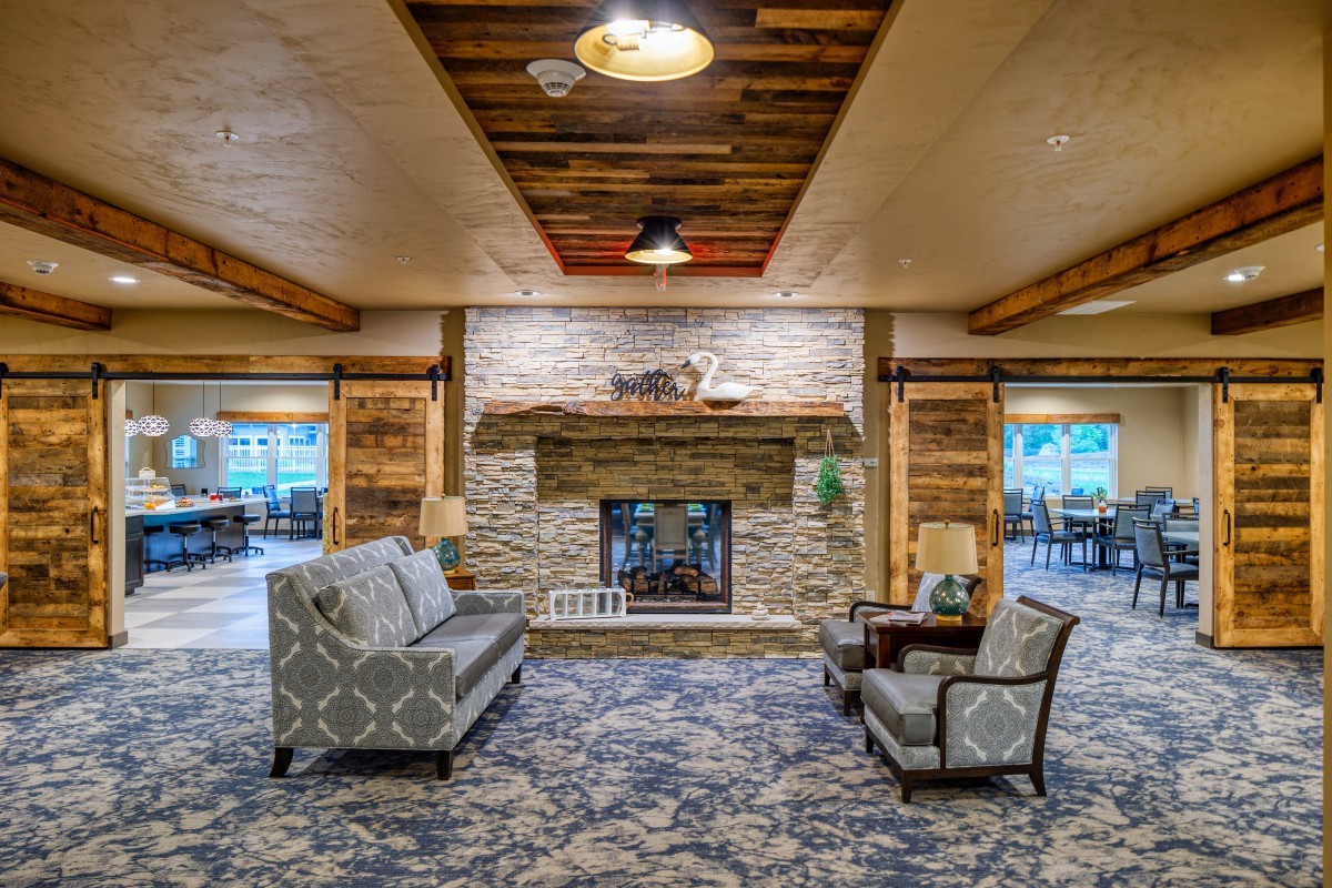 A cozy living room with a stone fireplace and elegant seating.
