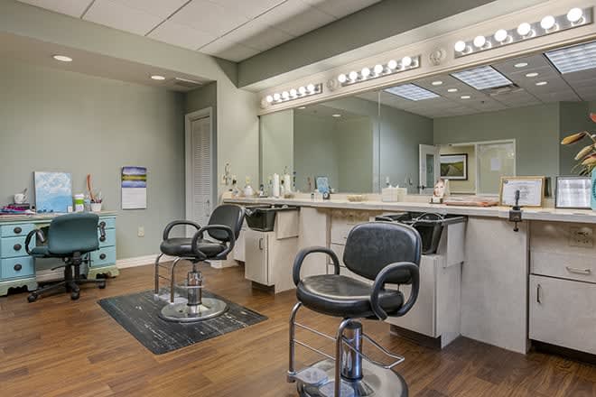 Interior view of an empty hair salon with chairs and mirrors.