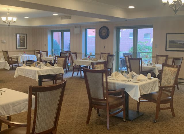 An empty dining room with neatly set tables and chairs.