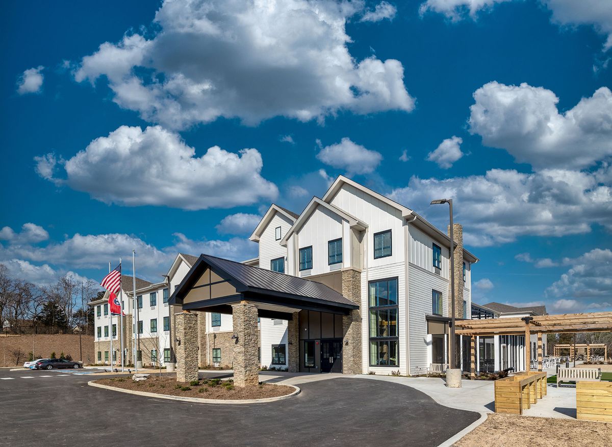 A modern hotel building under a partly cloudy sky.