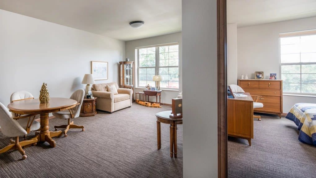 A cozy living room with a sofa, coffee table, and large window.