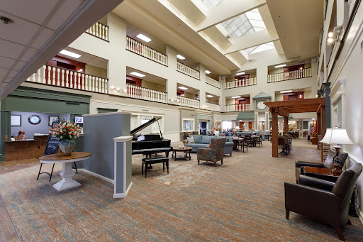 A spacious and elegantly designed interior lobby featuring comfortable seating, a grand piano, and ample natural light.