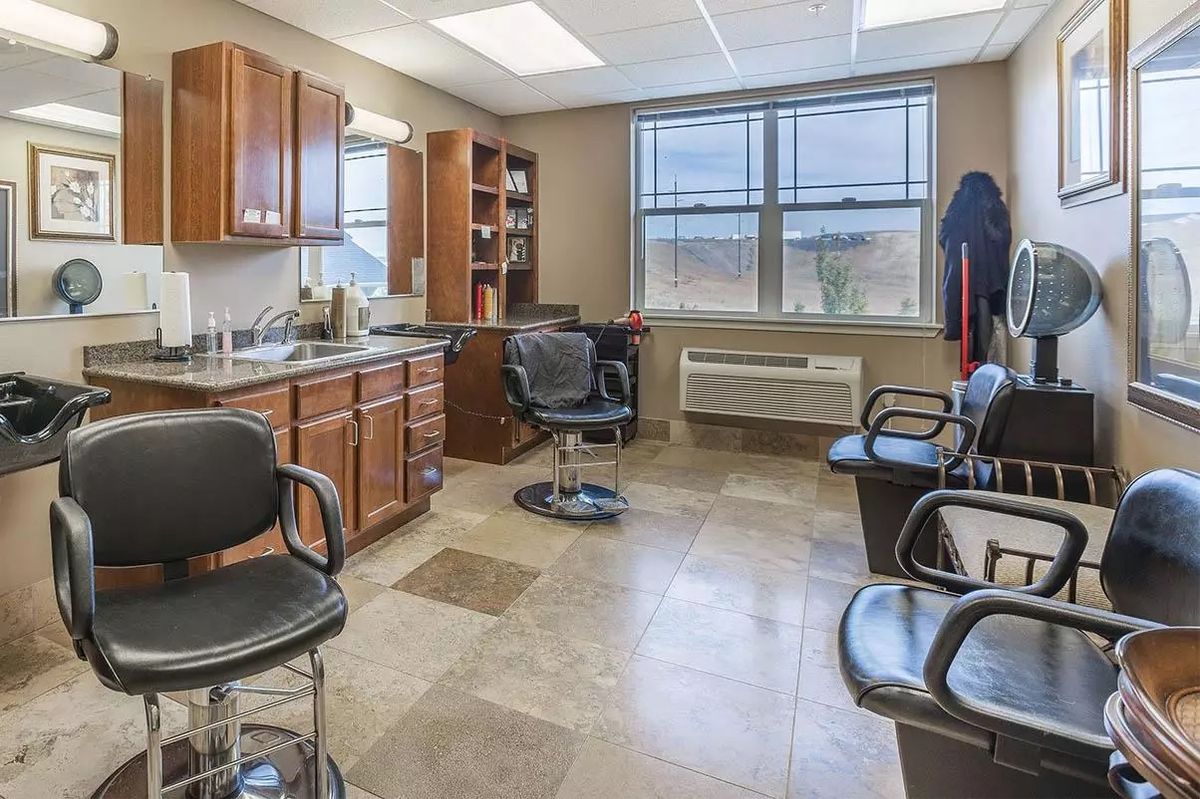 Interior view of a hair salon with chairs and cabinets.