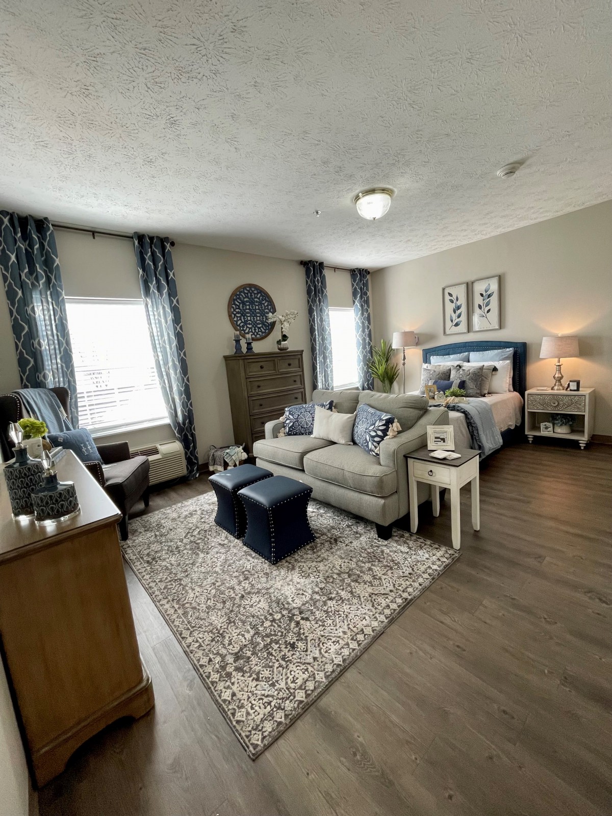 A spacious bedroom-living area combination featuring a sofa, bed, and elegant decor.
